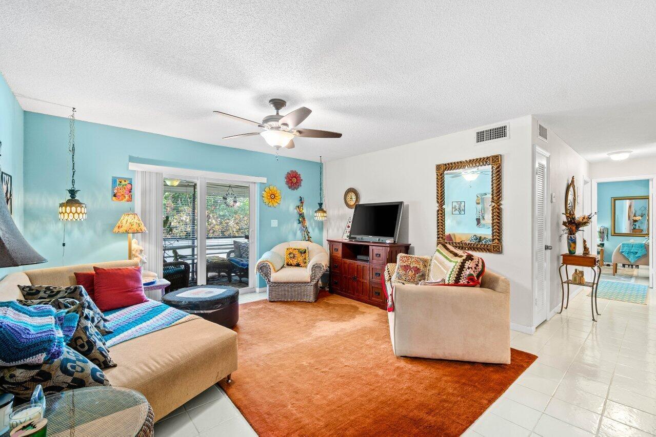 1124 Northwest 13th Street, Unit 204A Boca Raton, FL 33486 - Photo 4 of 30 a living room with furniture or couch and a flat screen tv