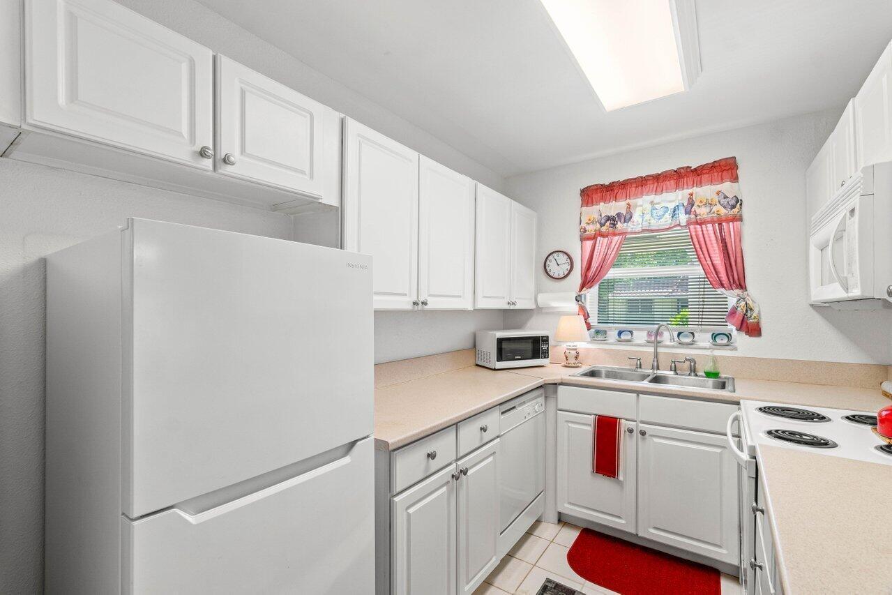 1124 Northwest 13th Street, Unit 204A Boca Raton, FL 33486 - Photo 8 of 30 a kitchen with a sink cabinets and window