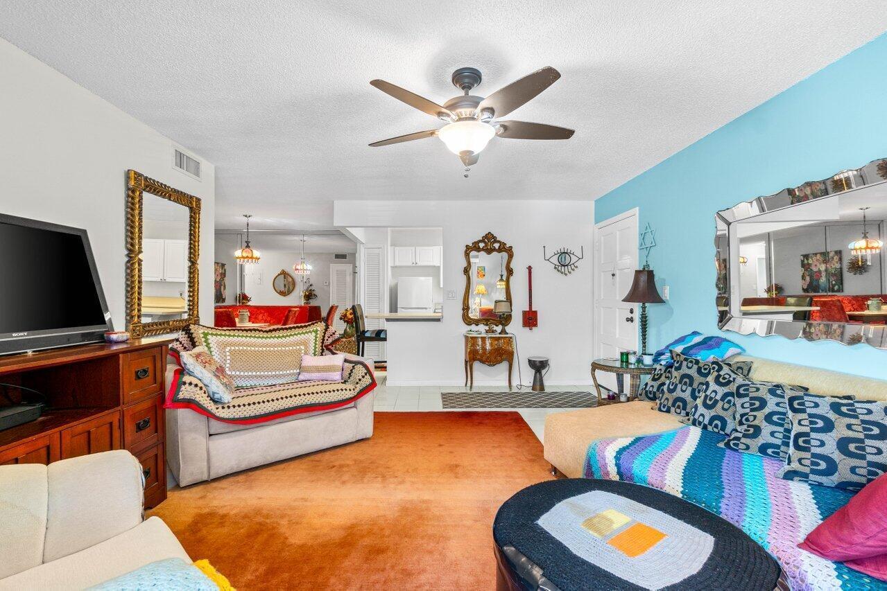 1124 Northwest 13th Street, Unit 204A Boca Raton, FL 33486 - Photo 10 of 30 a living room with furniture and a flat screen tv