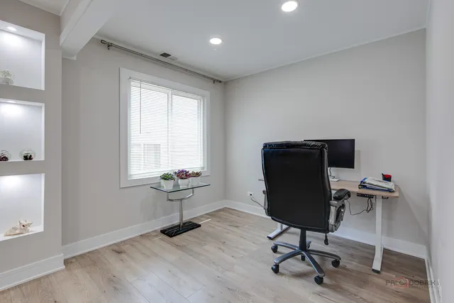 a view of a workspace with furniture and a window