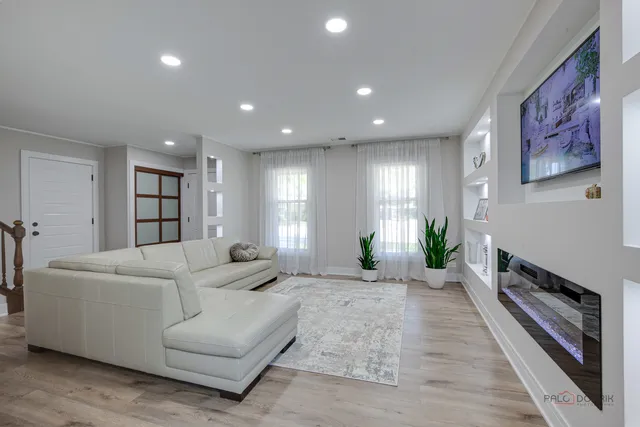 a living room with furniture a wooden floor and a ceiling fan