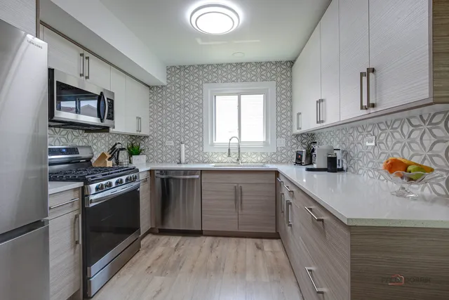 a kitchen with stainless steel appliances granite countertop a stove a sink and a refrigerator