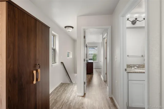 a view of a hallway with closet and wooden floor