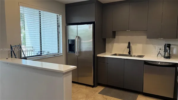 a kitchen with stainless steel appliances a sink and a refrigerator
