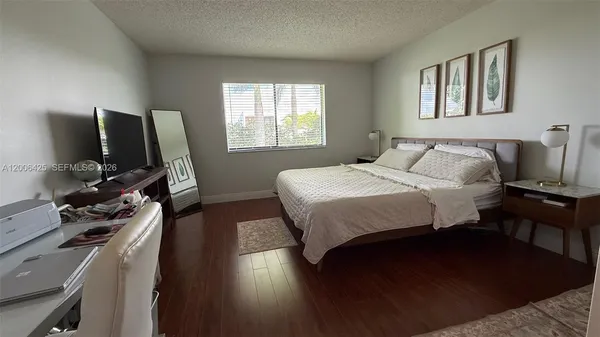 a bedroom with a bed tv and a window