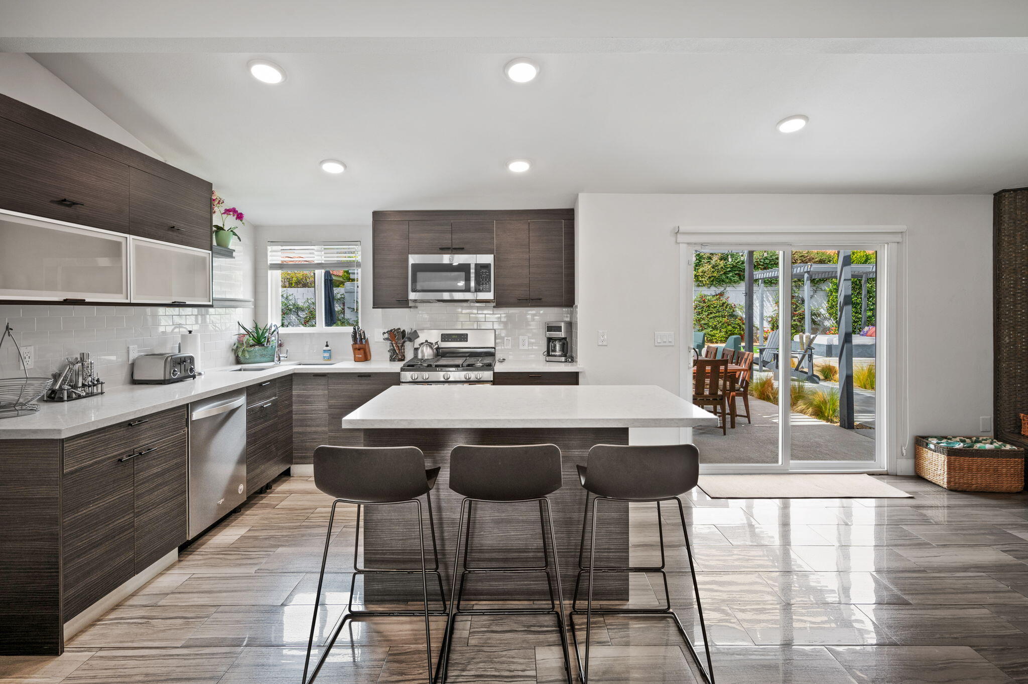 3059 North Biskra Road Palm Springs, CA 92262 - Photo 12 of 44 a kitchen with stainless steel appliances granite countertop a stove a sink a refrigerator white cabinets and chairs with wooden floor