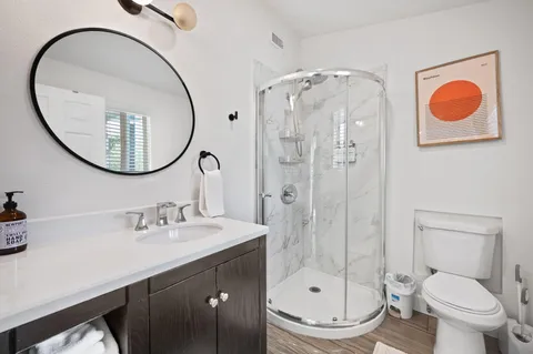 a bathroom with a sink a toilet and a mirror