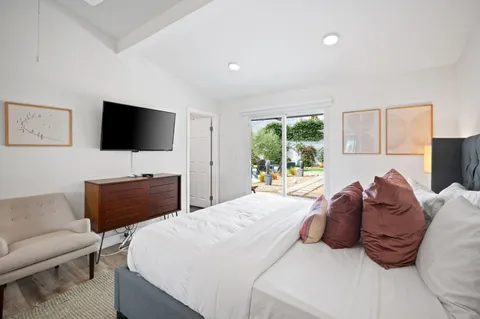 a bedroom with a bed and a flat screen tv