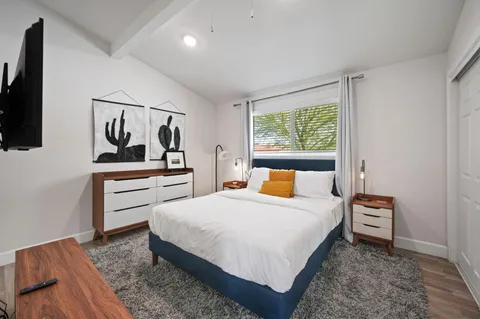 a bedroom with a bed and a flat screen tv