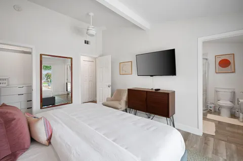 a bedroom with a bed and a flat screen tv