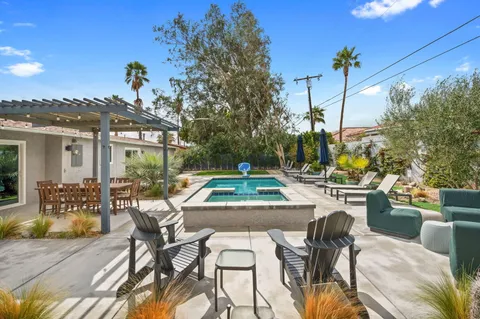 a view of a patio with couches table and chairs and potted plants