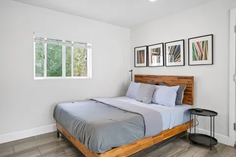 a bedroom with a bed and wooden floor