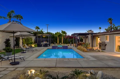 a view of a house with swimming pool and sitting area