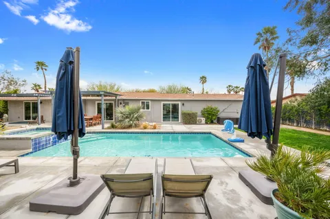 a view of house with backyard and outdoor seating