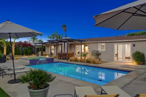a view of a house with swimming pool and sitting area