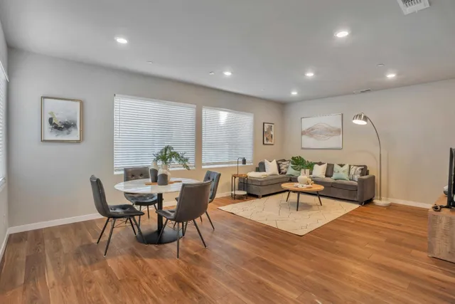 a view of a a dining room with furniture window and wooden floor