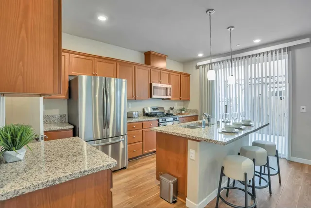 a kitchen with stainless steel appliances granite countertop a sink refrigerator and cabinets