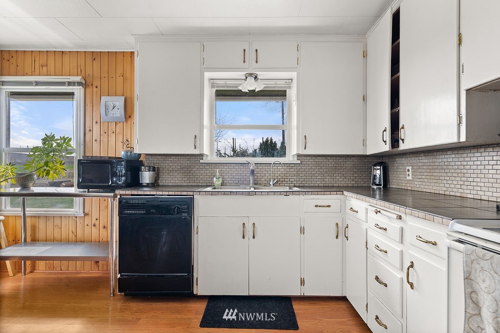 740 Gap Road Granger, WA 98932 - Photo 11 of 40 a kitchen with granite countertop white cabinets and white appliances