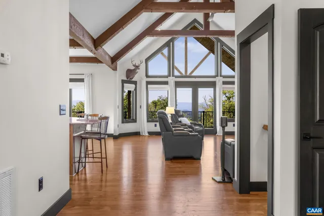 a view of a dining room and livingroom with furniture wooden floor a chandelier