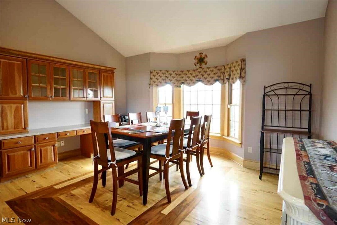 9835 Kile Road Chardon, OH 44024 - Photo 6 of 40 Dining space featuring high vaulted ceiling, light hardwood flooring, and built in desk