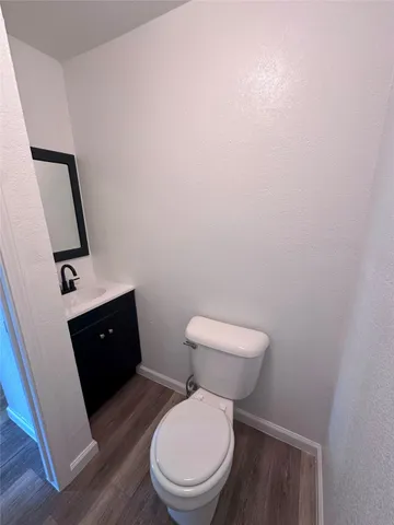 a toilet sitting in a bathroom next to a wooden cabinet
