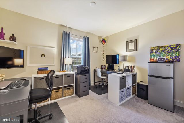 a room with furniture a flat screen tv and a refrigerator