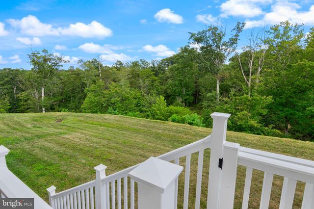 a view of a deck with a big yard and large trees