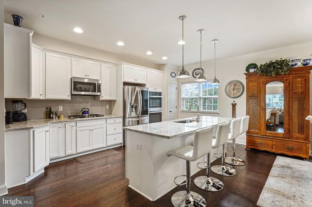 a kitchen with stainless steel appliances granite countertop a sink refrigerator and cabinets