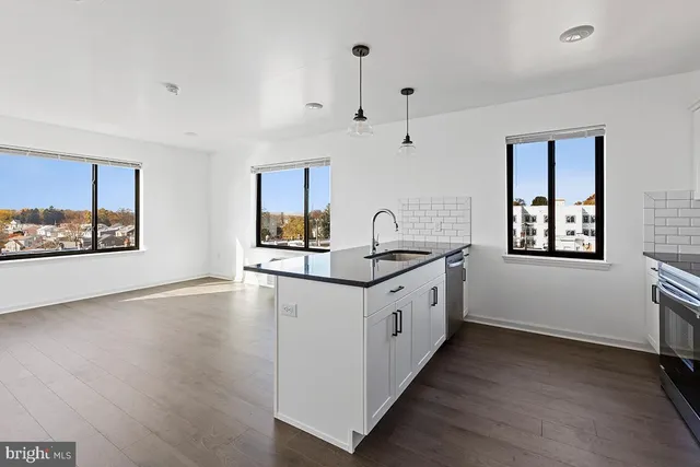 a kitchen with granite countertop a stove a sink and a wooden floors