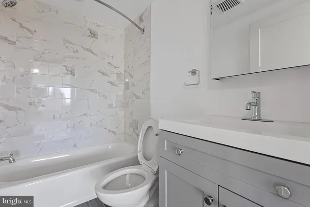 a bathroom with a sink a toilet and bathtub