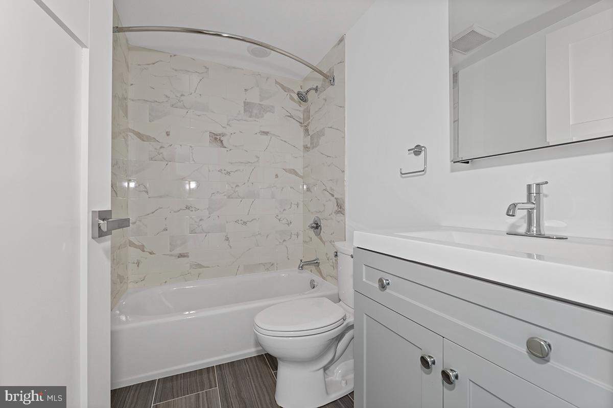 404 Fountain Street, Unit 307 Philadelphia, PA 19128 - Photo 14 of 15 a bathroom with a sink a toilet and shower
