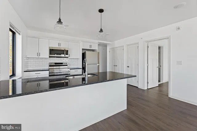 a large kitchen with kitchen island a sink stainless steel appliances and cabinets