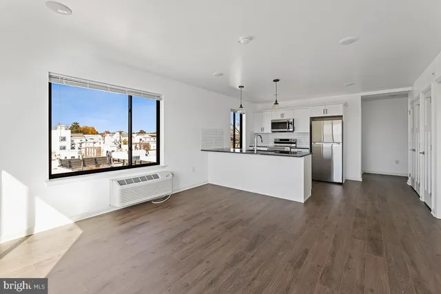 a view of a kitchen with a sink stove cabinets and empty room