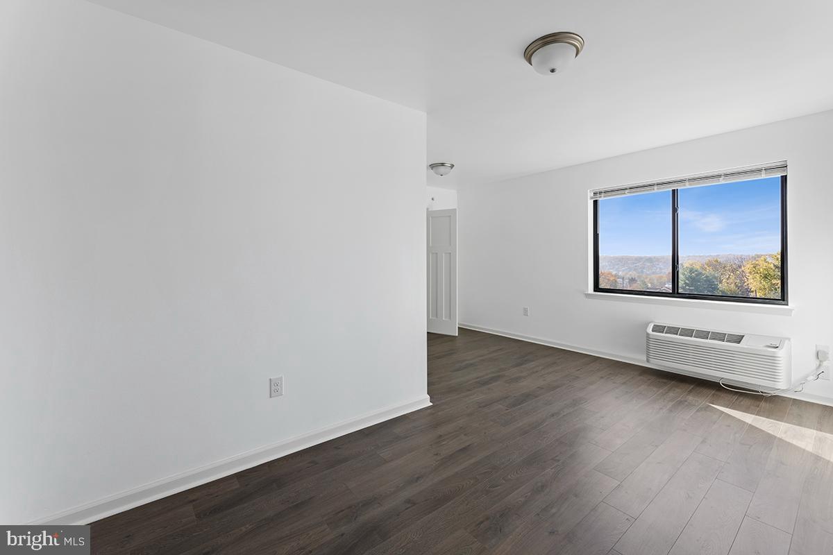404 Fountain Street, Unit 307 Philadelphia, PA 19128 - Photo 9 of 15 an empty room with wooden floor and windows