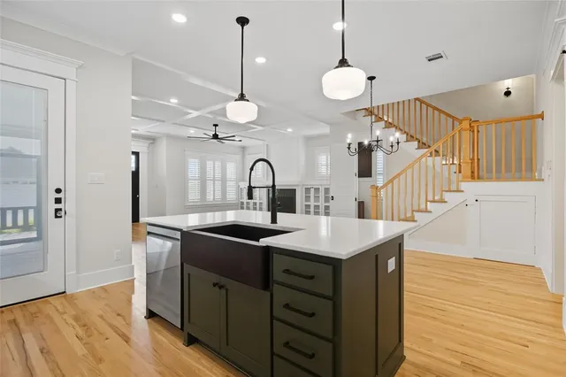 a kitchen with a sink and a wooden floor