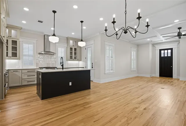 a kitchen with a sink chandelier and wooden floor