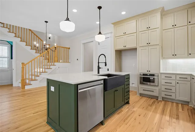a kitchen with granite countertop a stove a sink and a refrigerator
