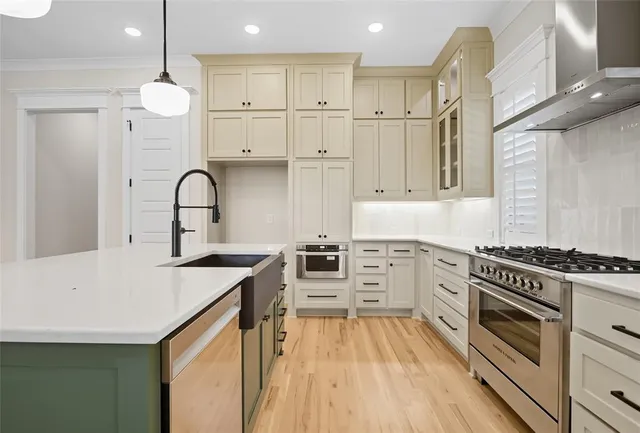 a kitchen with white cabinets appliances and wooden floor