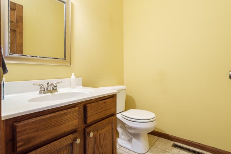 8833 West Ridge Drive Belvidere, IL 61008 - Photo 40 of 65 a bathroom with a granite countertop toilet sink and mirror