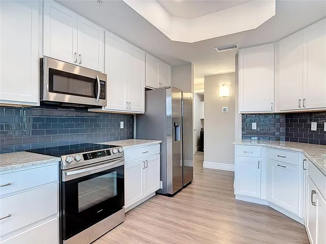a kitchen with stainless steel appliances a stove microwave and sink