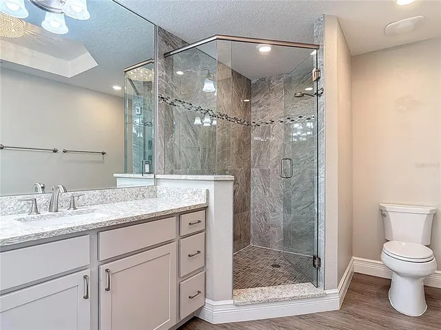 a kitchen with granite countertop a stove and a wooden floor