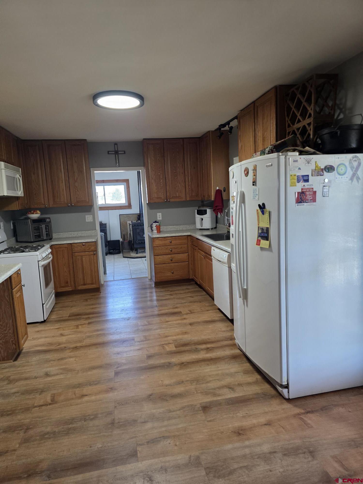 62500 Lasalle Road Montrose, CO 81403 - Photo 12 of 15 a kitchen with a refrigerator a stove top oven a sink dishwasher and wooden cabinets with wooden floor