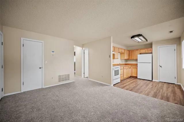a kitchen with stainless steel appliances white cabinets and wooden floors