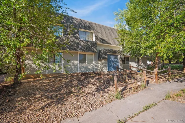 a backyard of a house with large trees and brick walls