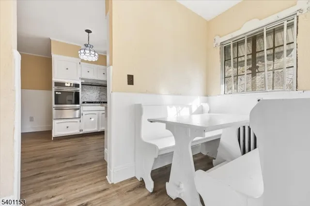 a kitchen with stainless steel appliances kitchen island granite countertop a table chairs in it and wooden floors