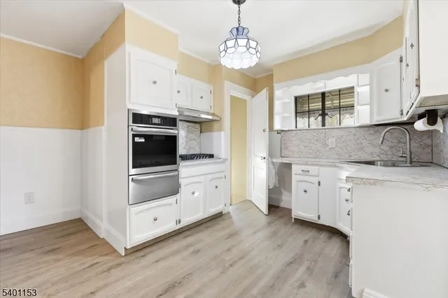 a kitchen with granite countertop a stove a sink and dishwasher with wooden floor