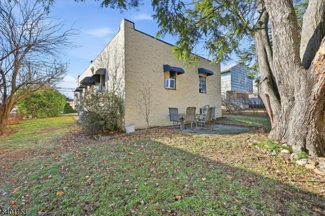 a view of a house with backyard and tree