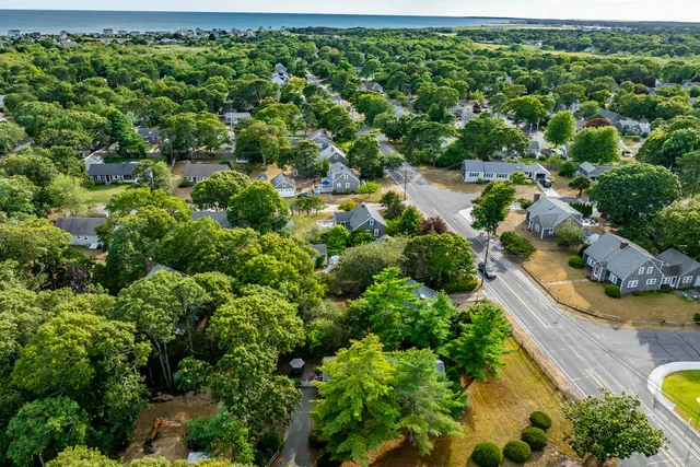 an aerial view of residential house with outdoor space and trees all around