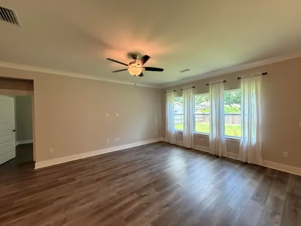 a view of room with window ceiling fan and hardwood floor