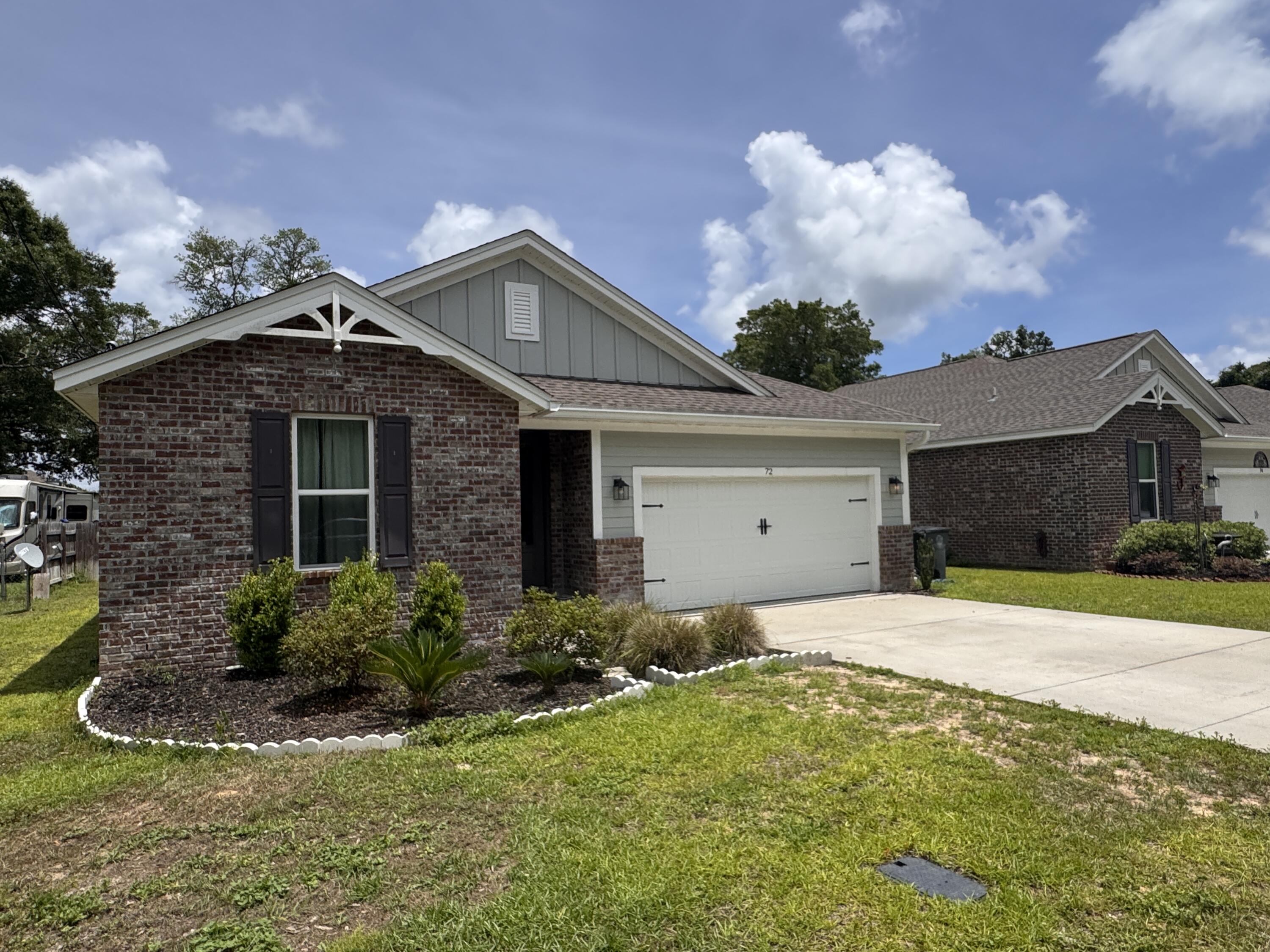 72 Wolverine Avenue Valparaiso, FL 32580 - Photo 2 of 20 a front view of a house with a yard and garage